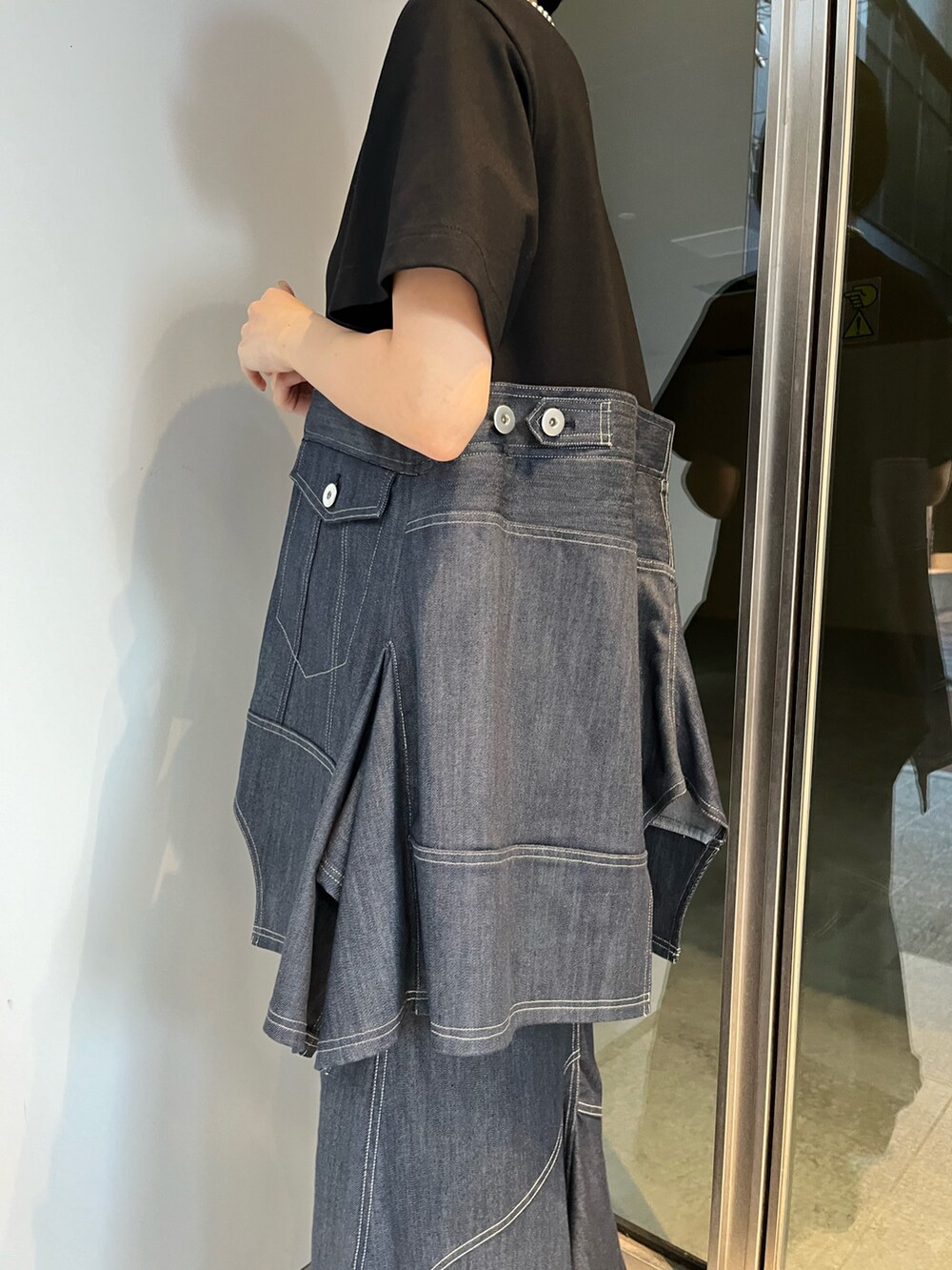 ブルー系のスカート、ブルー系のTシャツ/カットソー、ブラック系のブーツを着用したレディースの冬コーディネートの7枚目の写真