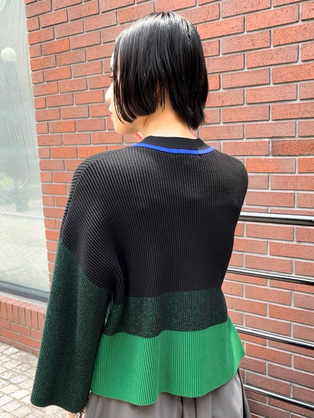 ブラック系のニット/セーター、グレー系のその他パンツ、シルバー系のパンプスを着用したレディースの夏コーディネートの5枚目の写真