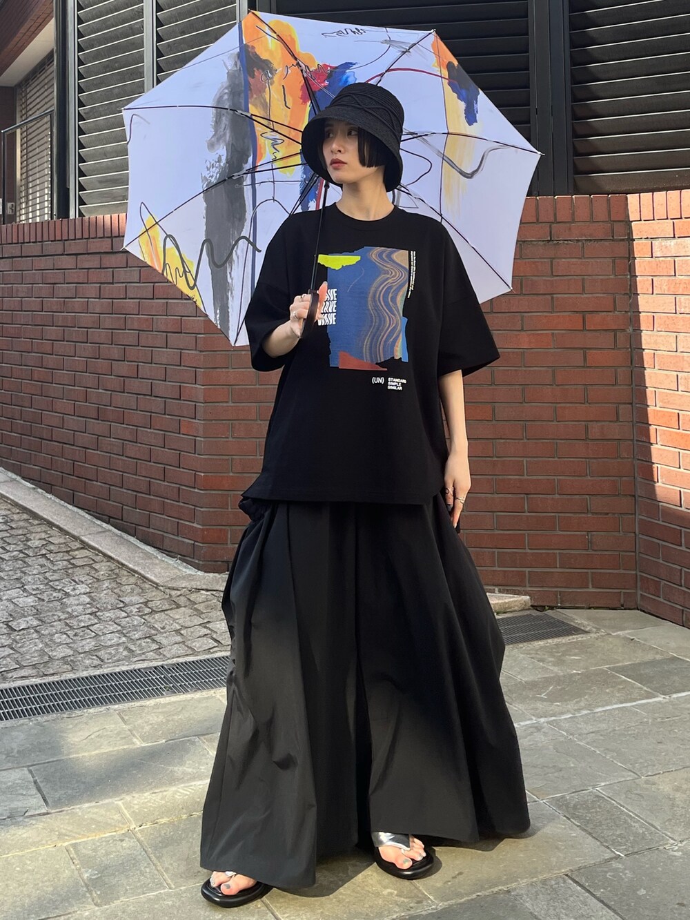 ブラック系のTシャツ/カットソー、ブラック系のその他パンツ、シルバー系のサンダルを着用したレディースの春コーディネートの4枚目の写真