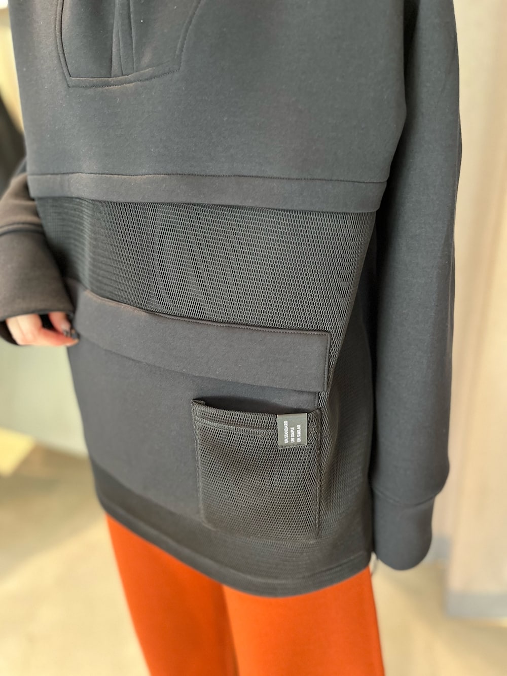 ブラック系のスウェット、オレンジ系のその他パンツ、ブラック系のブーツを着用したレディースの秋コーディネートの6枚目の写真