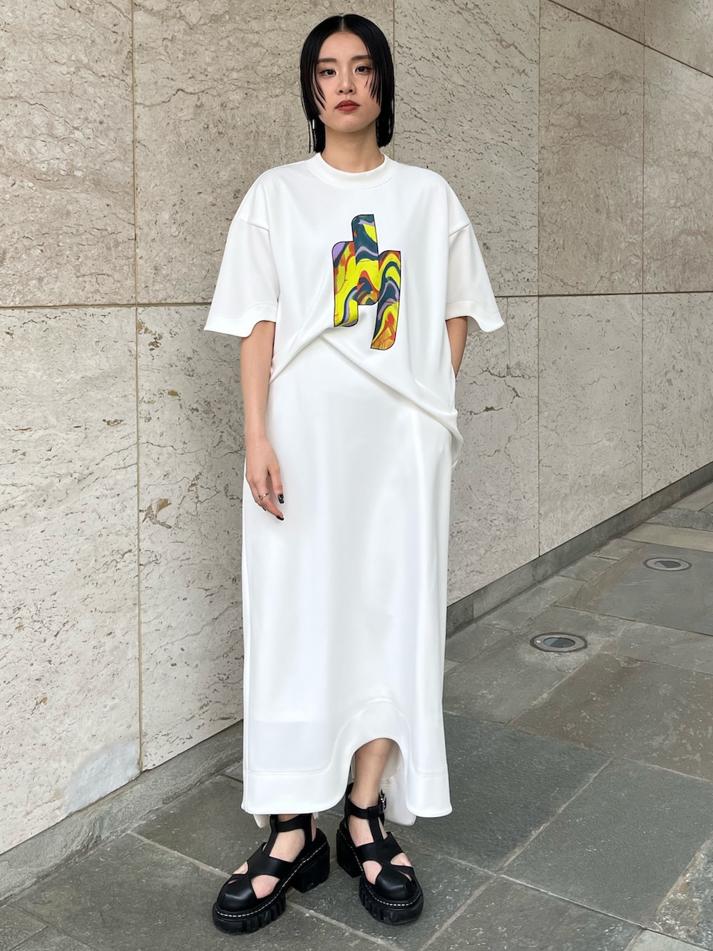 ホワイト系のワンピース、ブラック系のサンダル、ブラック系のイヤリングを着用したレディースの冬コーディネートの2枚目の写真