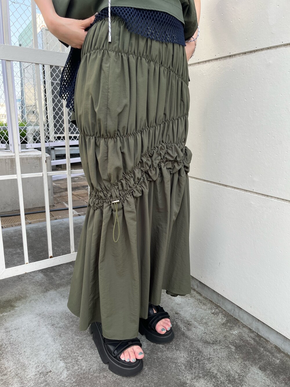 その他のタンクトップ、グリーン系のスカート、ブラック系のボディバッグ/ウエストポーチを着用したレディースの春コーディネートの9枚目の写真