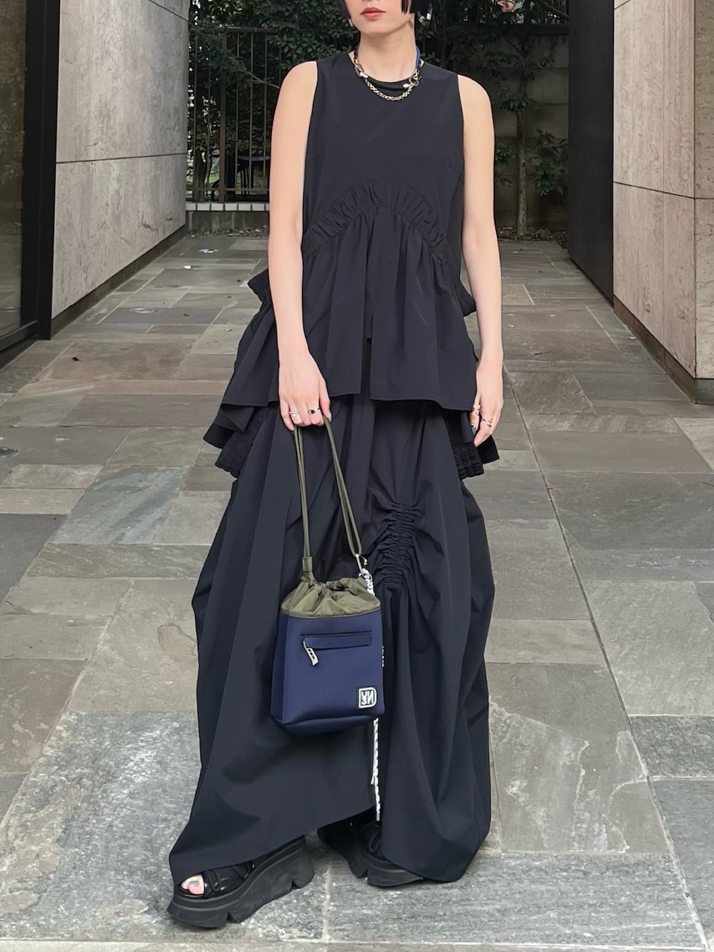 ブラック系のタンクトップ、ブラック系のスカート、ブラック系のサンダルを着用したレディースの春コーディネートの2枚目の写真