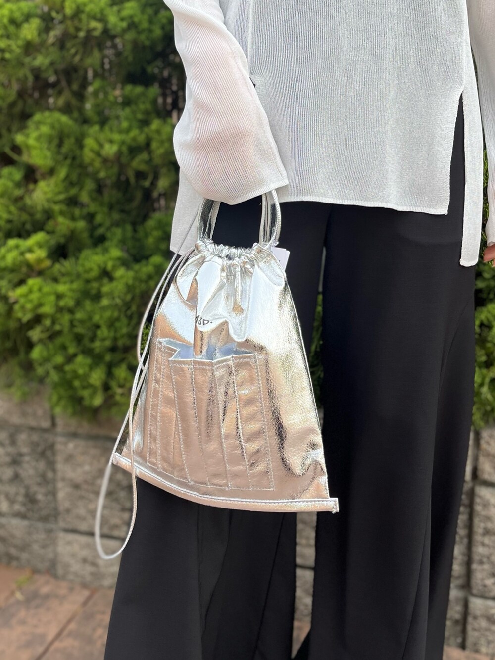 ホワイト系のニット/セーター、ブラック系のその他パンツ、シルバー系のショルダーバッグを着用したレディースの春コーディネートの8枚目の写真