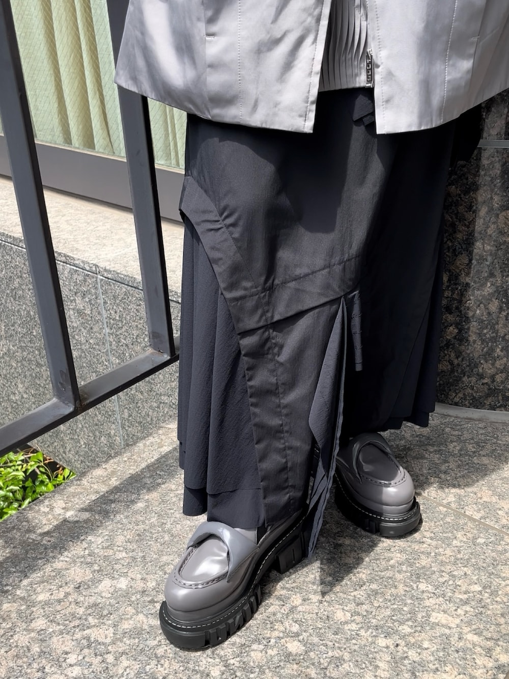 ブラック系のスカート、ブラック系のTシャツ/カットソー、グレー系のローファーを着用したレディースの夏コーディネートの9枚目の写真