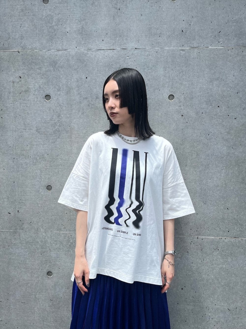 ホワイト系のTシャツ/カットソー、ブルー系のスカート、ブラック系のスニーカーを着用したレディースの夏コーディネートの5枚目の写真