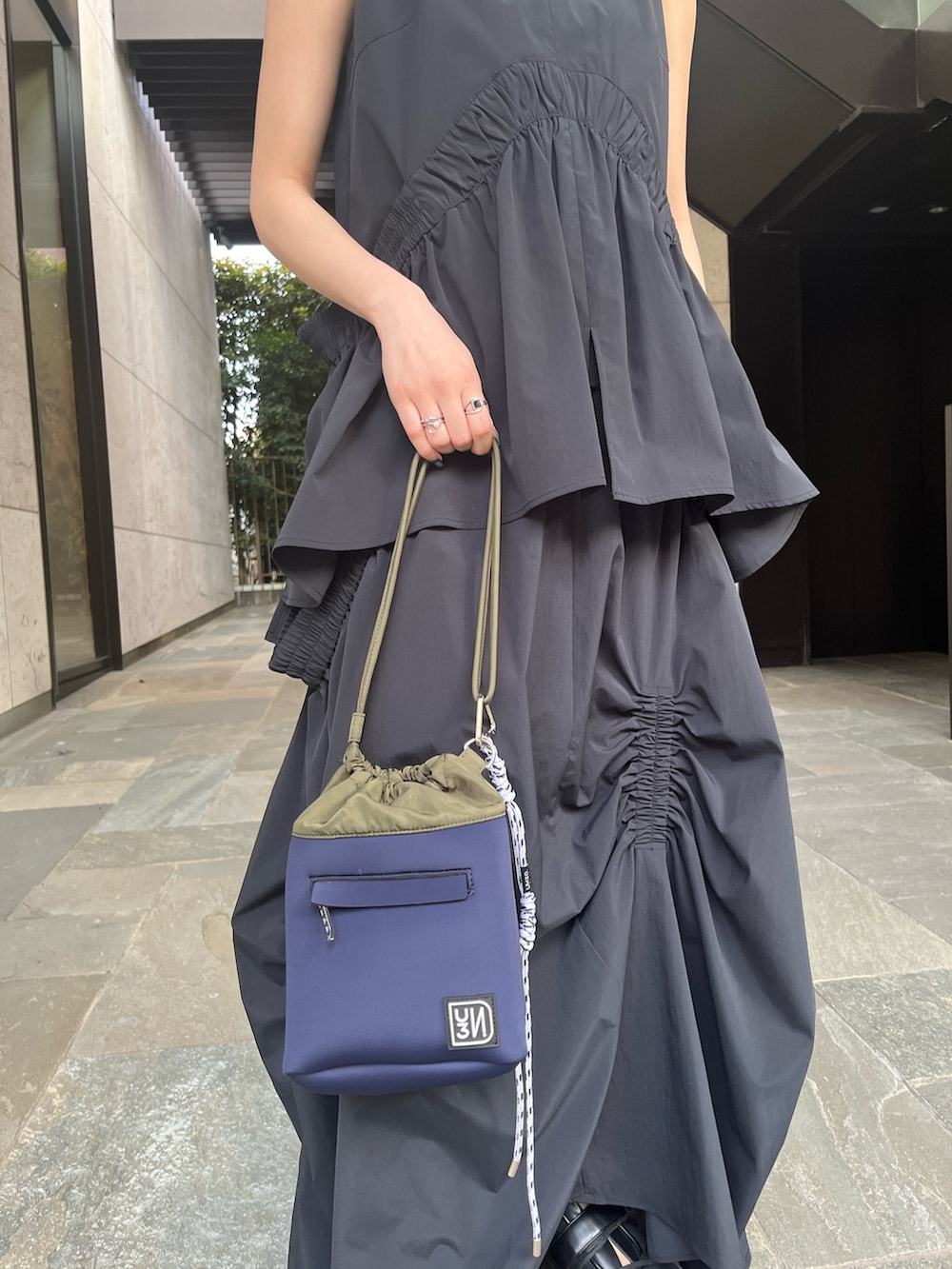 ブラック系のタンクトップ、ブラック系のスカート、ブラック系のサンダルを着用したレディースの春コーディネートの8枚目の写真