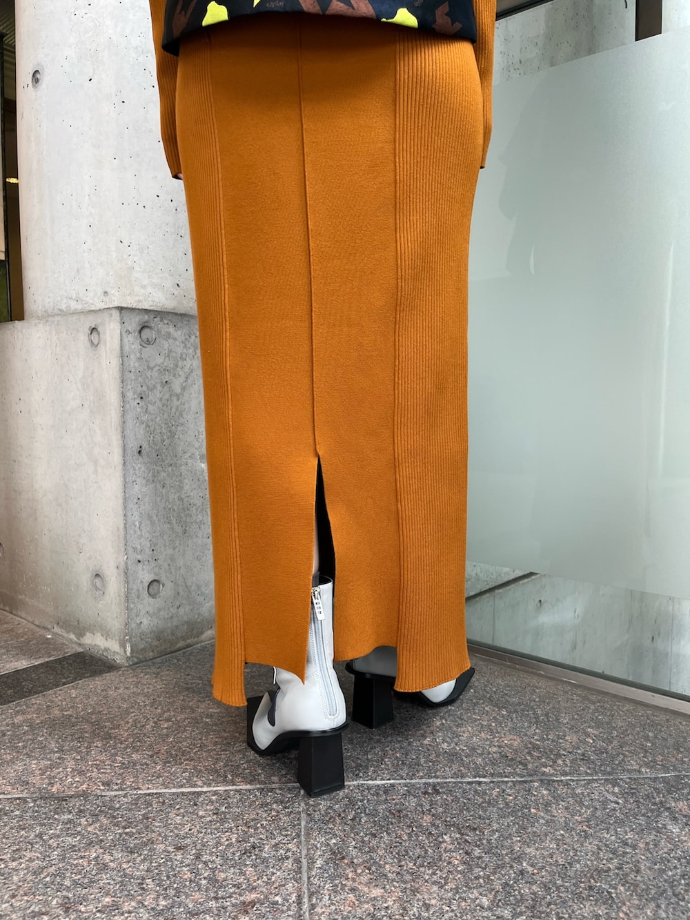 イエロー系のワンピース、ブラック系のキャミソール、その他のブーツを着用したレディースの秋コーディネートの7枚目の写真