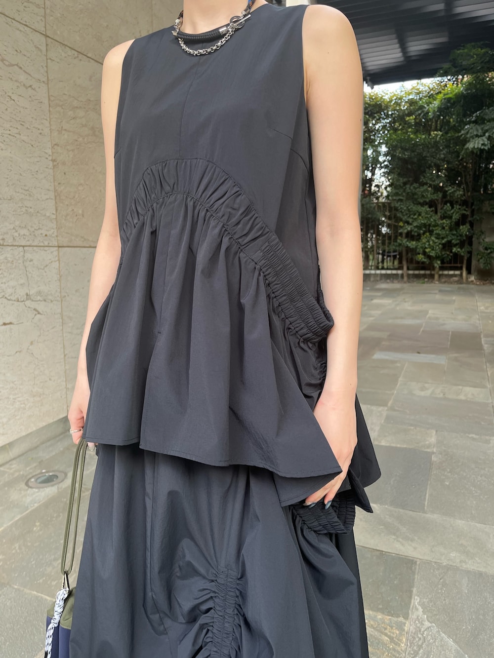 ブラック系のタンクトップ、ブラック系のスカート、ブラック系のサンダルを着用したレディースの春コーディネートの7枚目の写真