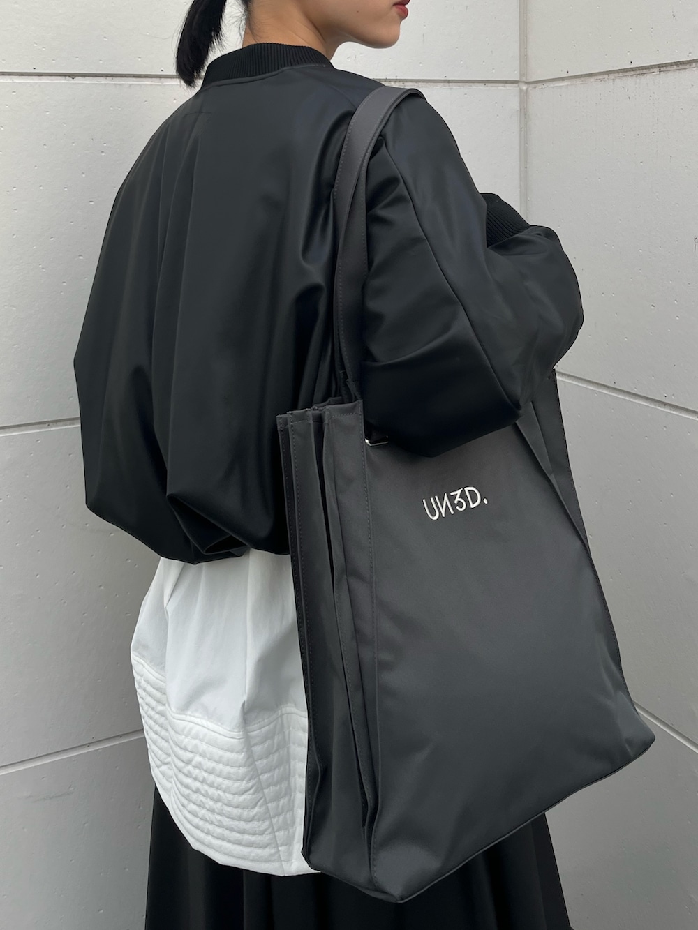 ブラック系のブーツ、ホワイト系のニット/セーター、ホワイト系のシャツ/ブラウスを着用したレディースの秋コーディネートの5枚目の写真