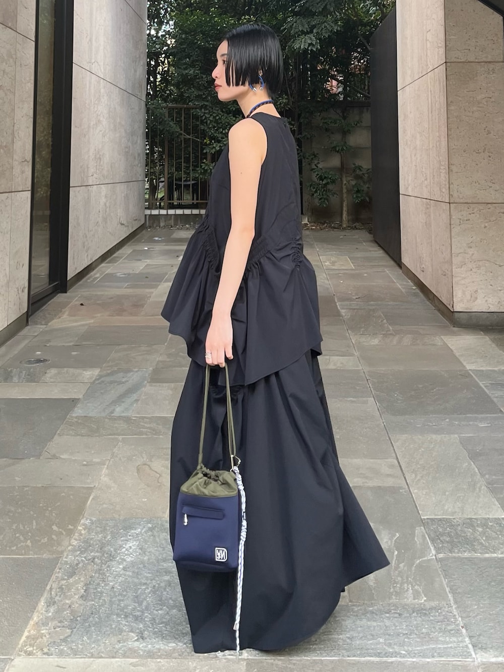 ブラック系のタンクトップ、ブラック系のスカート、ブラック系のサンダルを着用したレディースの春コーディネートの4枚目の写真