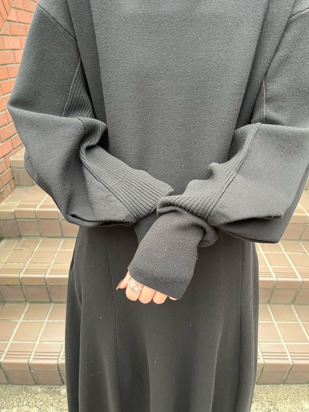 ブラック系のワンピース、シルバー系のブーツ、ブラウン系のネックレスを着用したレディースの秋コーディネートの6枚目の写真