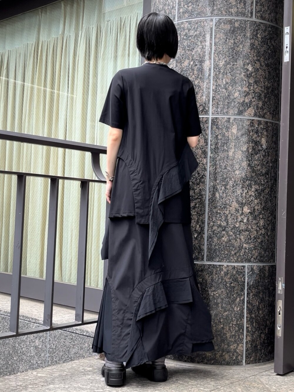 ブラック系のTシャツ/カットソー、ブラック系のスカート、グレー系のローファーを着用したレディースの秋コーディネートの2枚目の写真