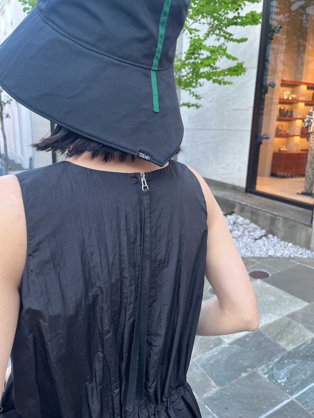 ブラック系のワンピース、ブラック系のサンダル、ブラック系のハットを着用したレディースの春コーディネートの9枚目の写真