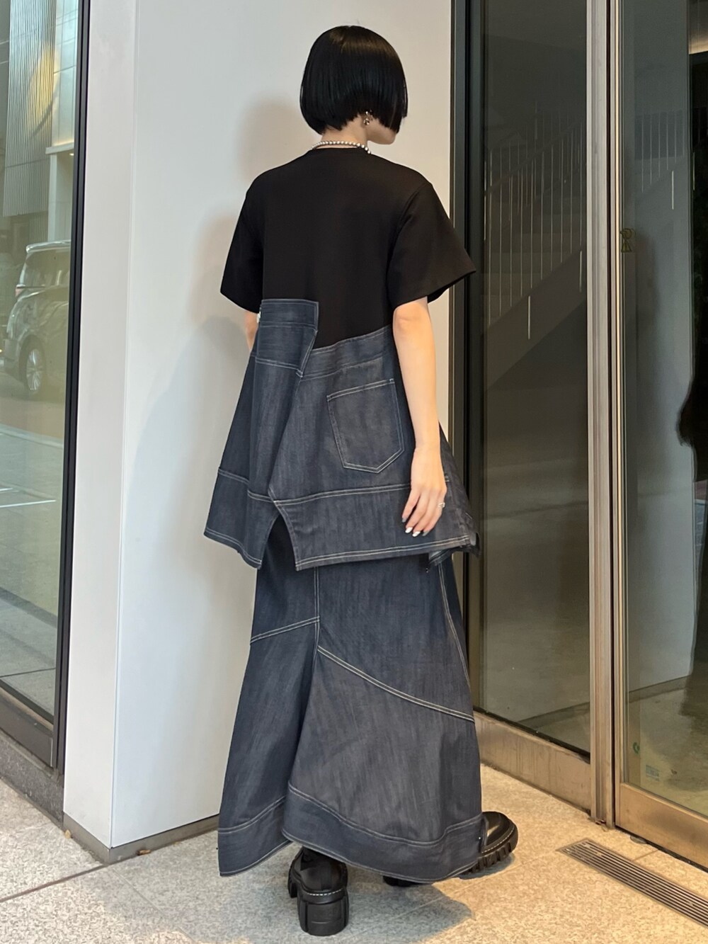 ブルー系のスカート、ブルー系のTシャツ/カットソー、ブラック系のブーツを着用したレディースの冬コーディネートの3枚目の写真