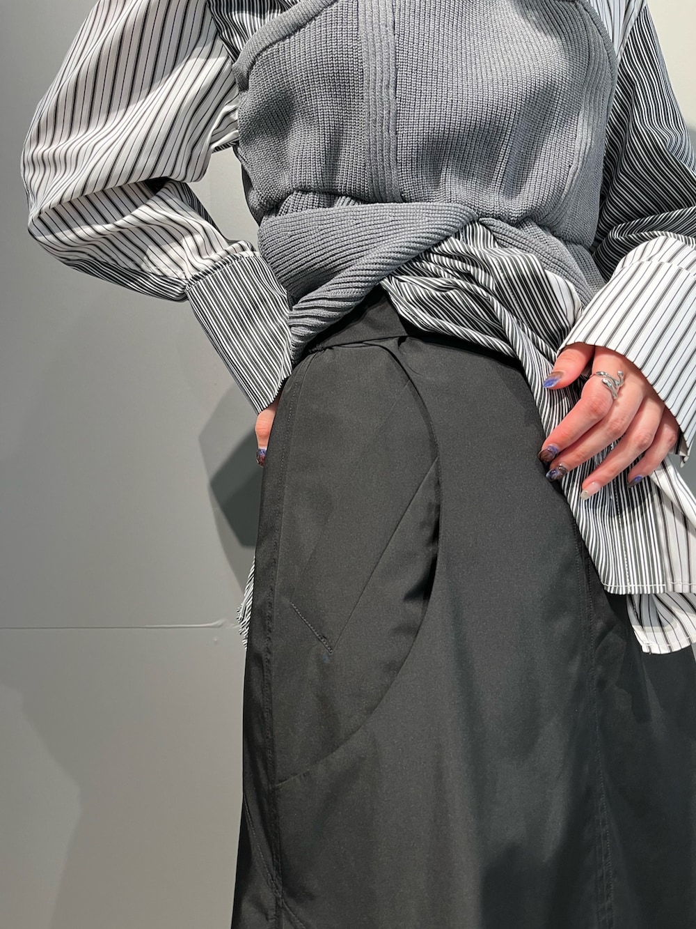 グレー系のシャツ/ブラウス、ブラック系のスカート、シルバー系のブーツを着用したレディースの秋コーディネートの9枚目の写真