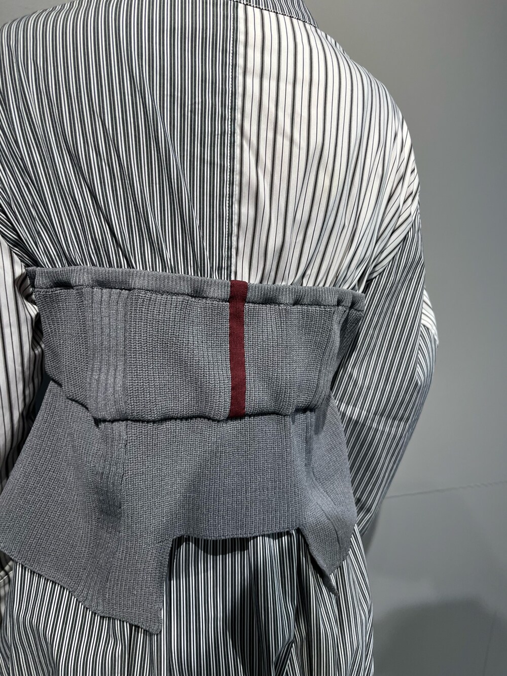 グレー系のシャツ/ブラウス、ブラック系のスカート、シルバー系のブーツを着用したレディースの秋コーディネートの8枚目の写真