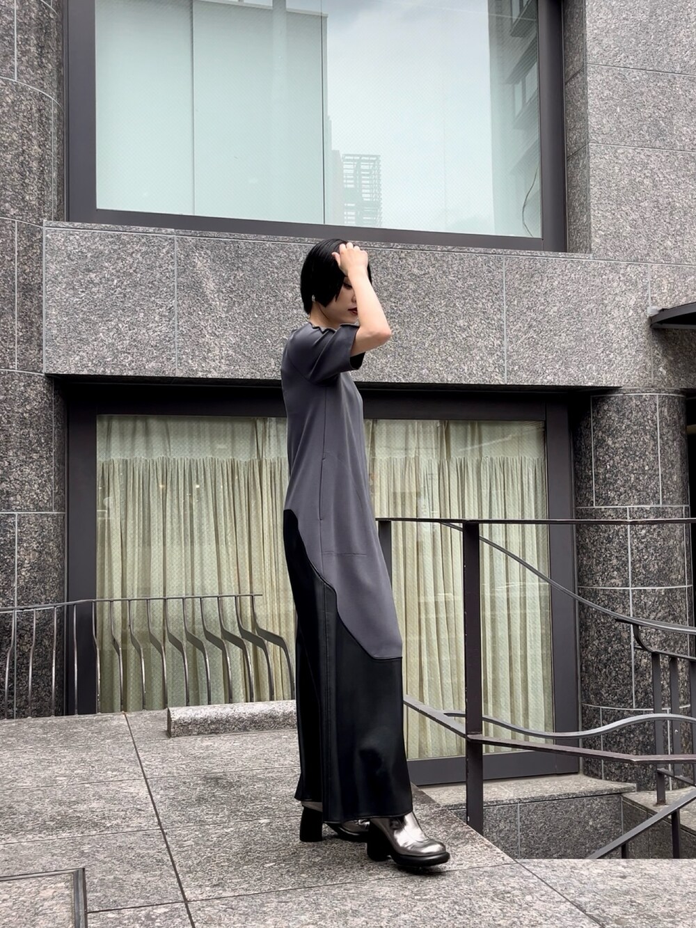 グレー系のワンピース、シルバー系のブーツ、シルバー系のネックレスを着用したレディースの夏コーディネートの6枚目の写真