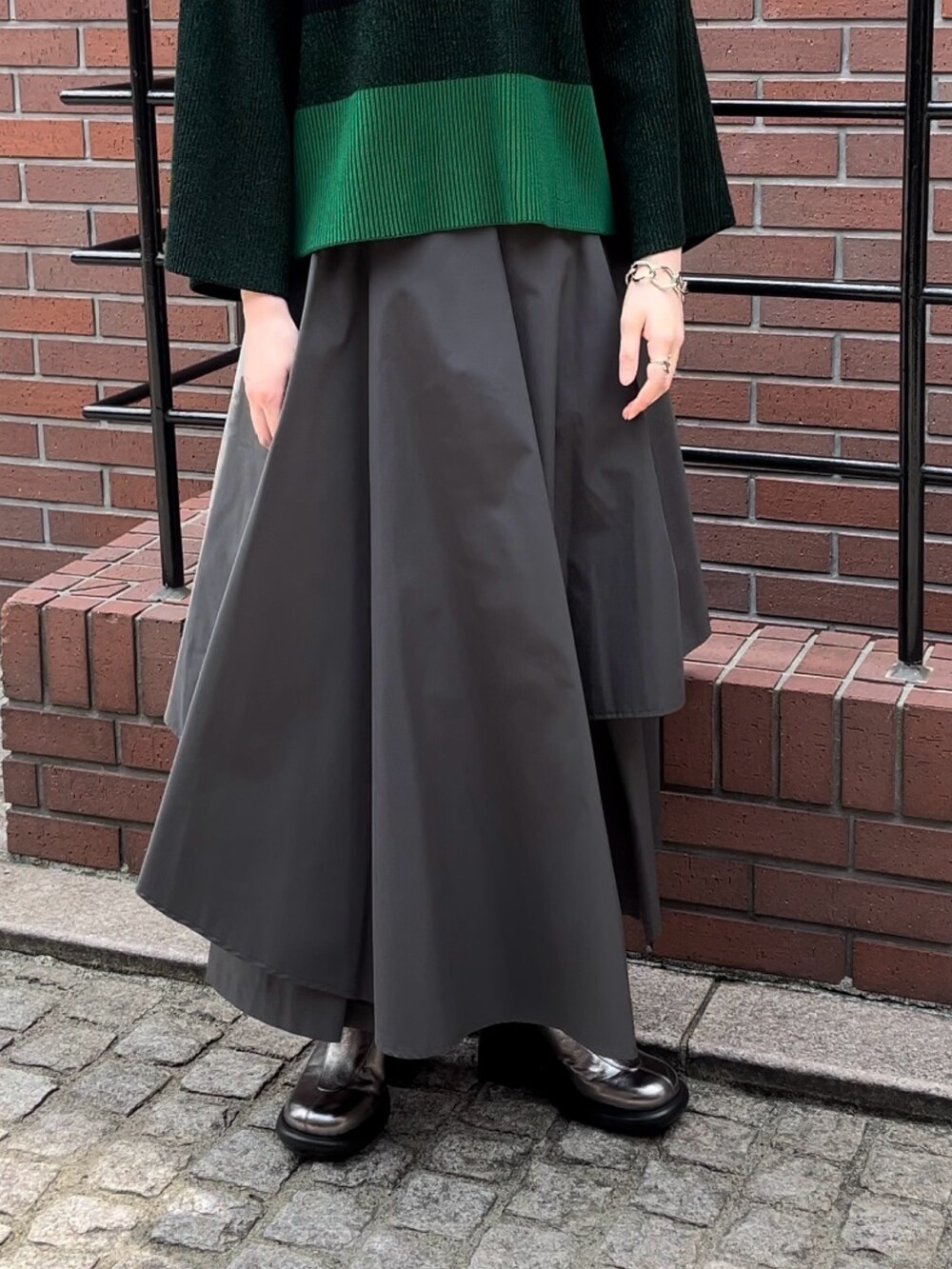 ブラック系のニット/セーター、グレー系のその他パンツ、シルバー系のパンプスを着用したレディースの夏コーディネートの7枚目の写真