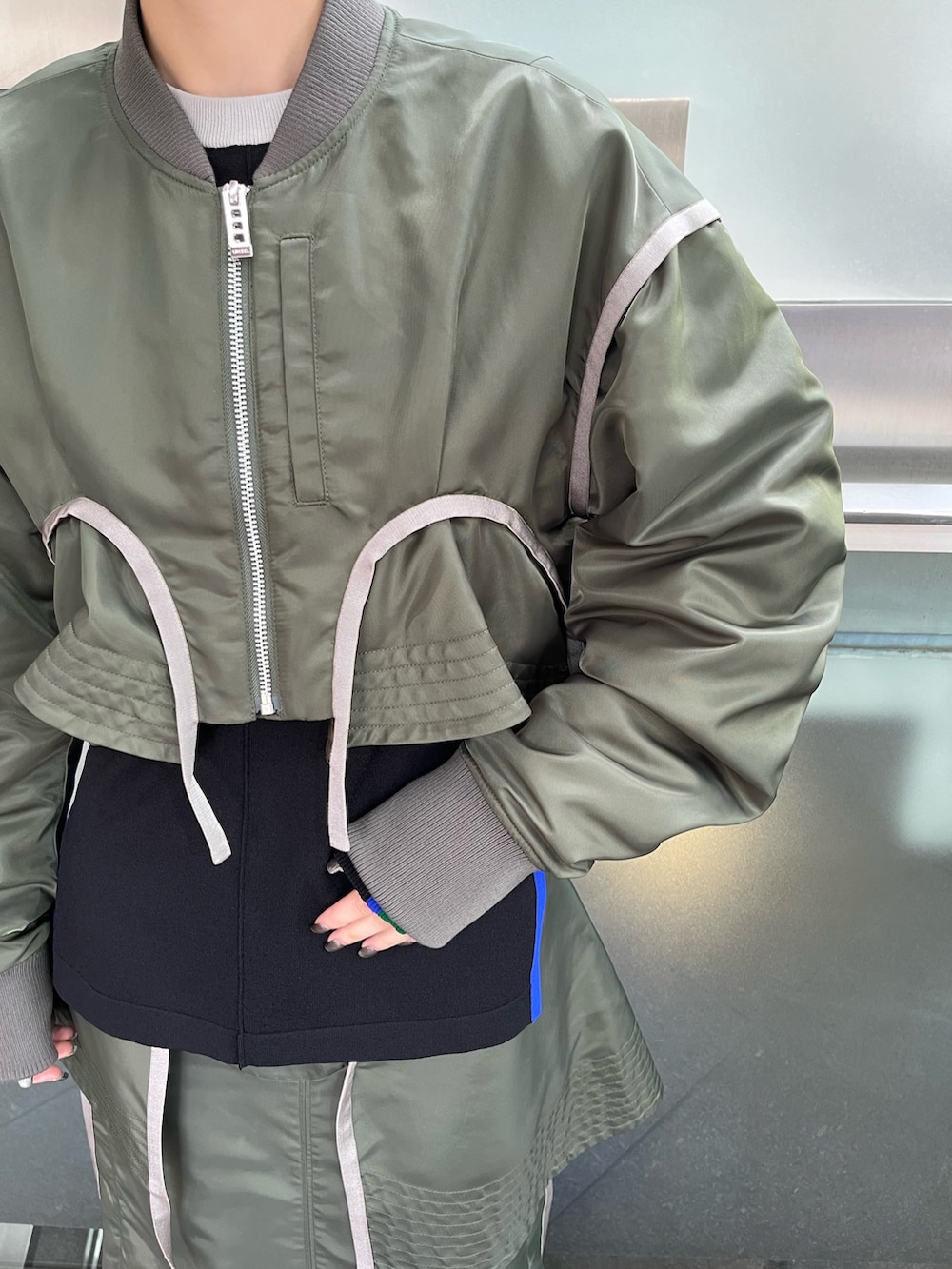 ベージュ系のMA-1、ベージュ系のスカート、ブラック系のニット/セーターを着用したレディースの秋コーディネートの6枚目の写真