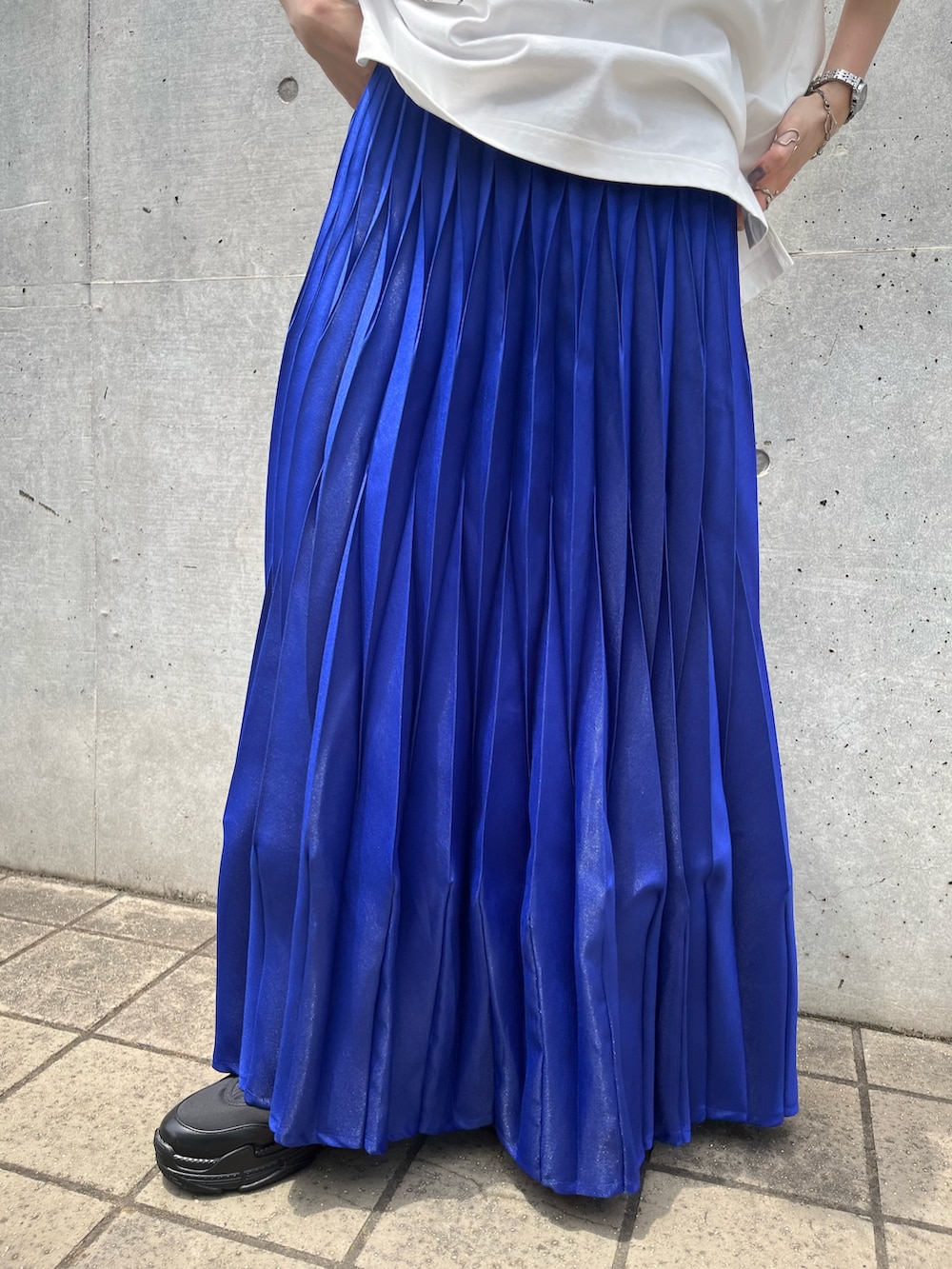 ホワイト系のTシャツ/カットソー、ブルー系のスカート、ブラック系のスニーカーを着用したレディースの夏コーディネートの8枚目の写真