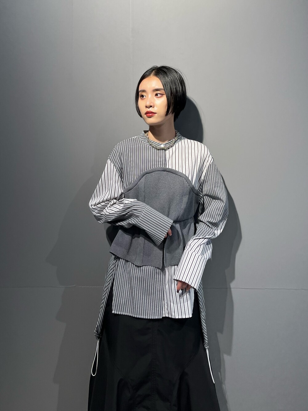 グレー系のシャツ/ブラウス、ブラック系のスカート、シルバー系のブーツを着用したレディースの秋コーディネートの5枚目の写真