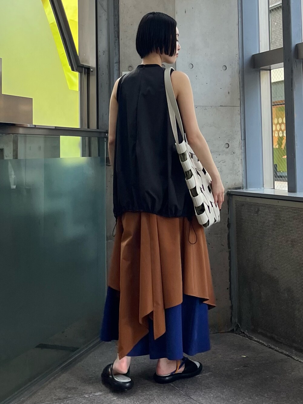 ベージュ系のトートバッグ、ブラック系のTシャツ/カットソー、イエロー系のその他パンツを着用したレディースの春コーディネートの4枚目の写真