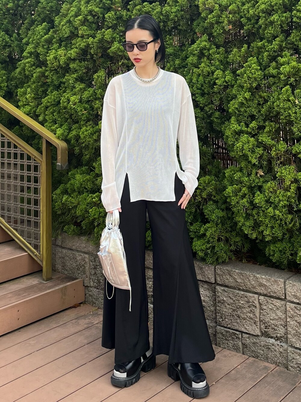 ホワイト系のニット/セーター、ブラック系のその他パンツ、シルバー系のショルダーバッグを着用したレディースの春コーディネートの3枚目の写真