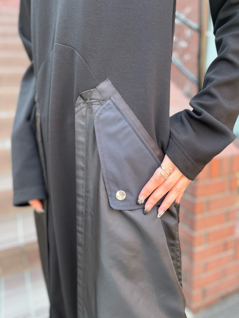 ブラック系のワンピース、ブラック系のローファー、シルバー系のイヤリングを着用したレディースの秋コーディネートの6枚目の写真