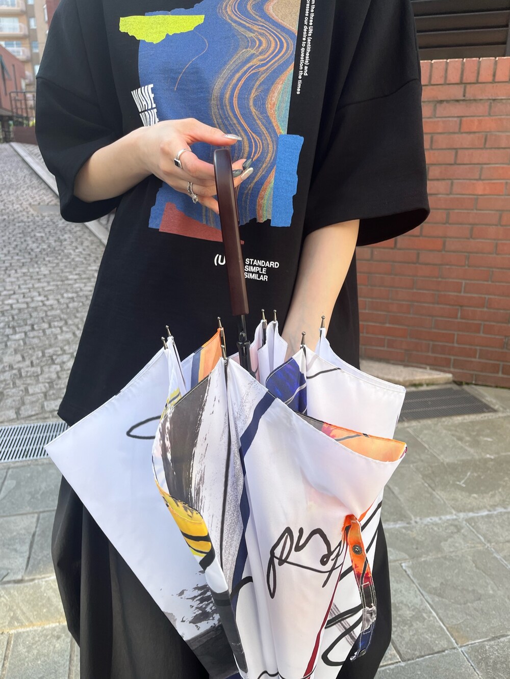 ブラック系のTシャツ/カットソー、ブラック系のその他パンツ、シルバー系のサンダルを着用したレディースの春コーディネートの6枚目の写真