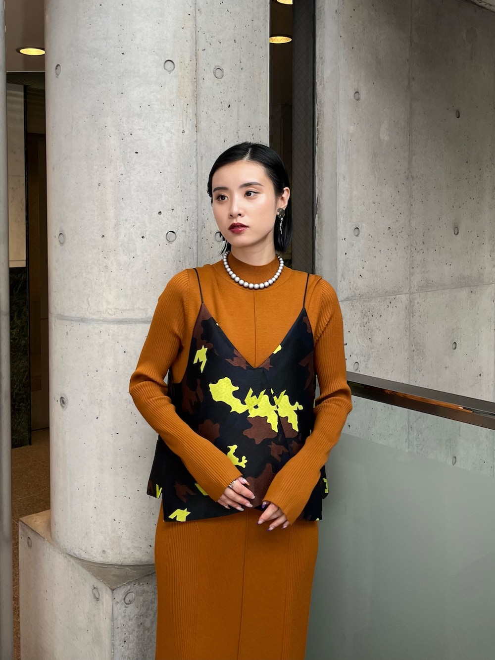 イエロー系のワンピース、ブラック系のキャミソール、その他のブーツを着用したレディースの秋コーディネートの4枚目の写真