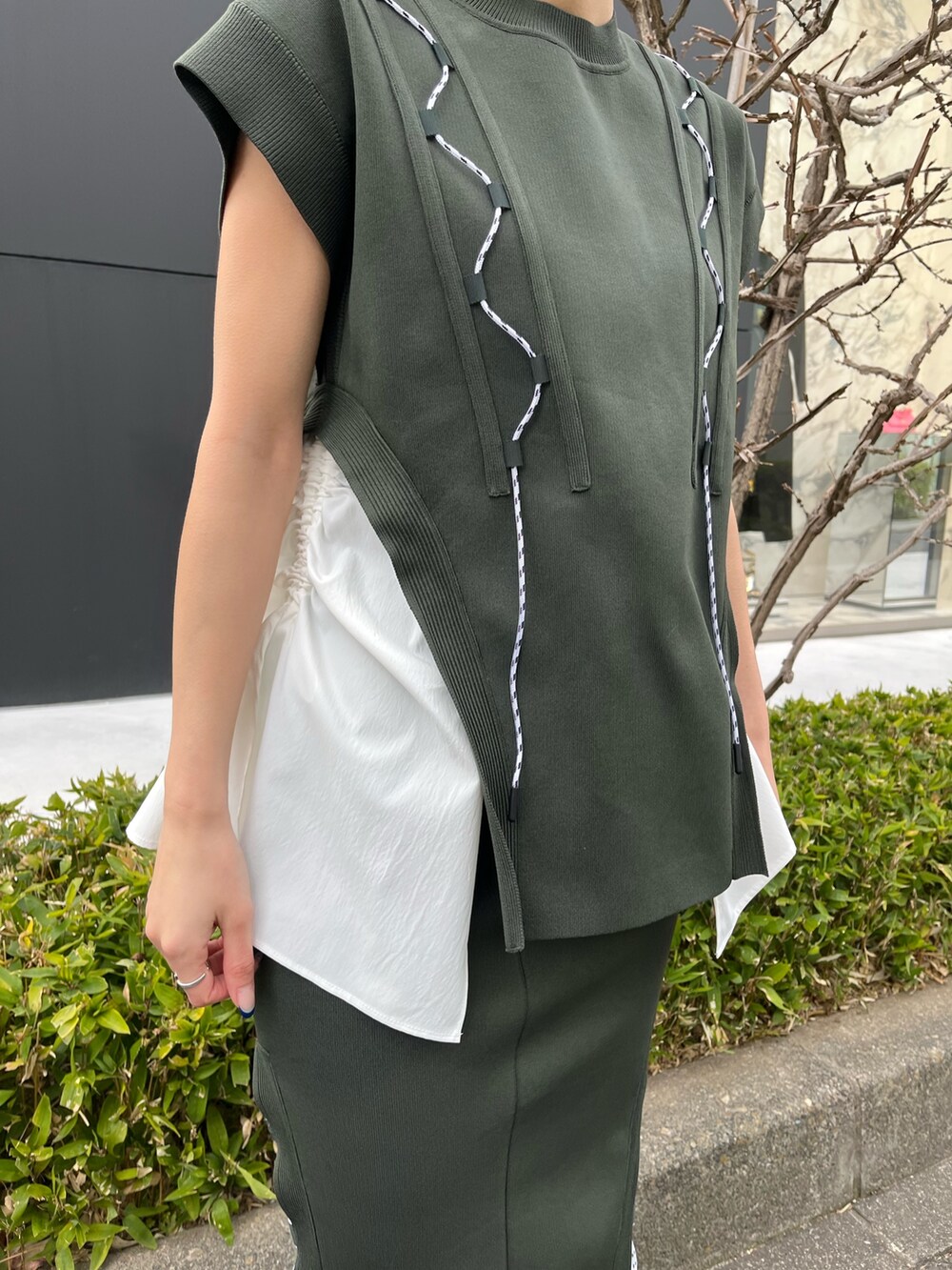 グリーン系のニット/セーター、グリーン系のスカート、ベージュ系のブーツを着用したレディースの春コーディネートの7枚目の写真