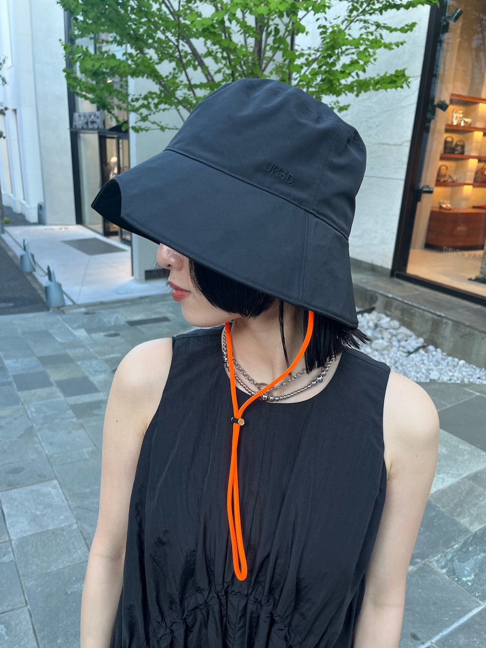 ブラック系のワンピース、ブラック系のサンダル、ブラック系のハットを着用したレディースの春コーディネートの6枚目の写真