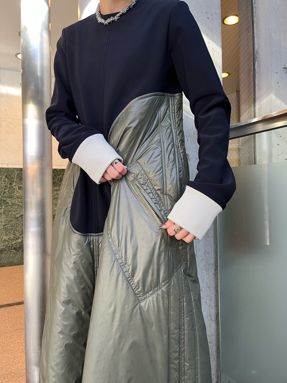 ベージュ系のワンピース、ブラック系のブーツ、シルバー系のネックレスを着用したレディースの秋コーディネートの9枚目の写真