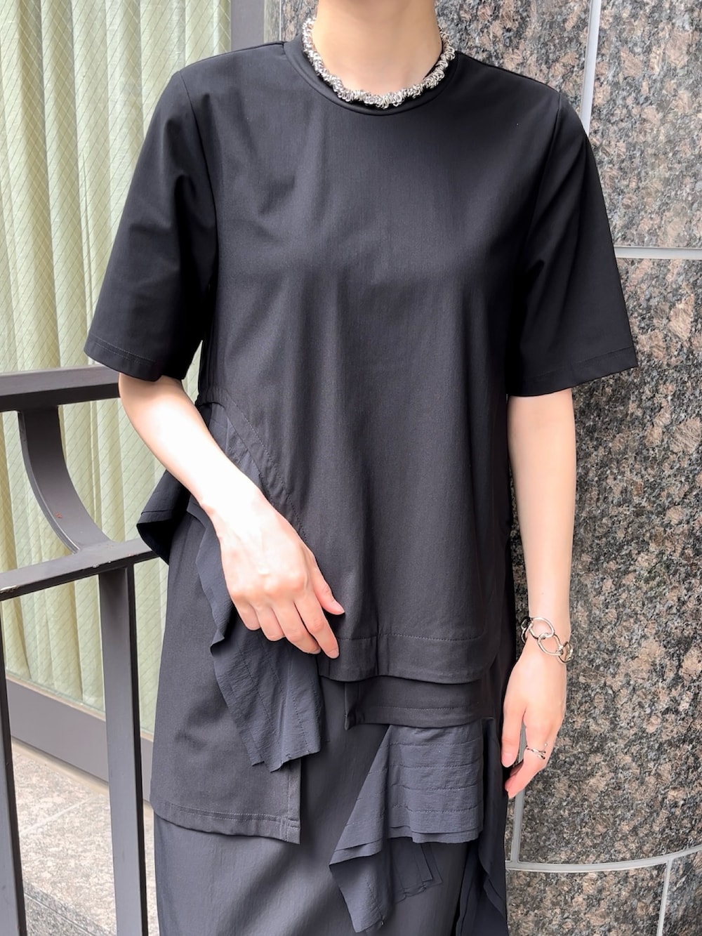 ブラック系のTシャツ/カットソー、ブラック系のスカート、グレー系のローファーを着用したレディースの秋コーディネートの5枚目の写真