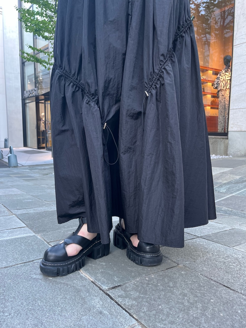 ブラック系のワンピース、ブラック系のサンダル、ブラック系のハットを着用したレディースの春コーディネートの8枚目の写真