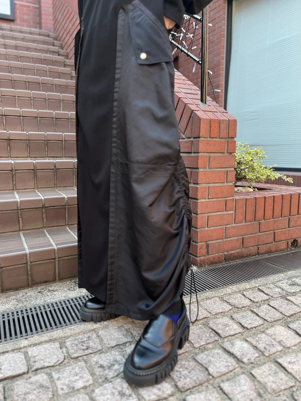 ブラック系のワンピース、ブラック系のローファー、シルバー系のイヤリングを着用したレディースの秋コーディネートの5枚目の写真