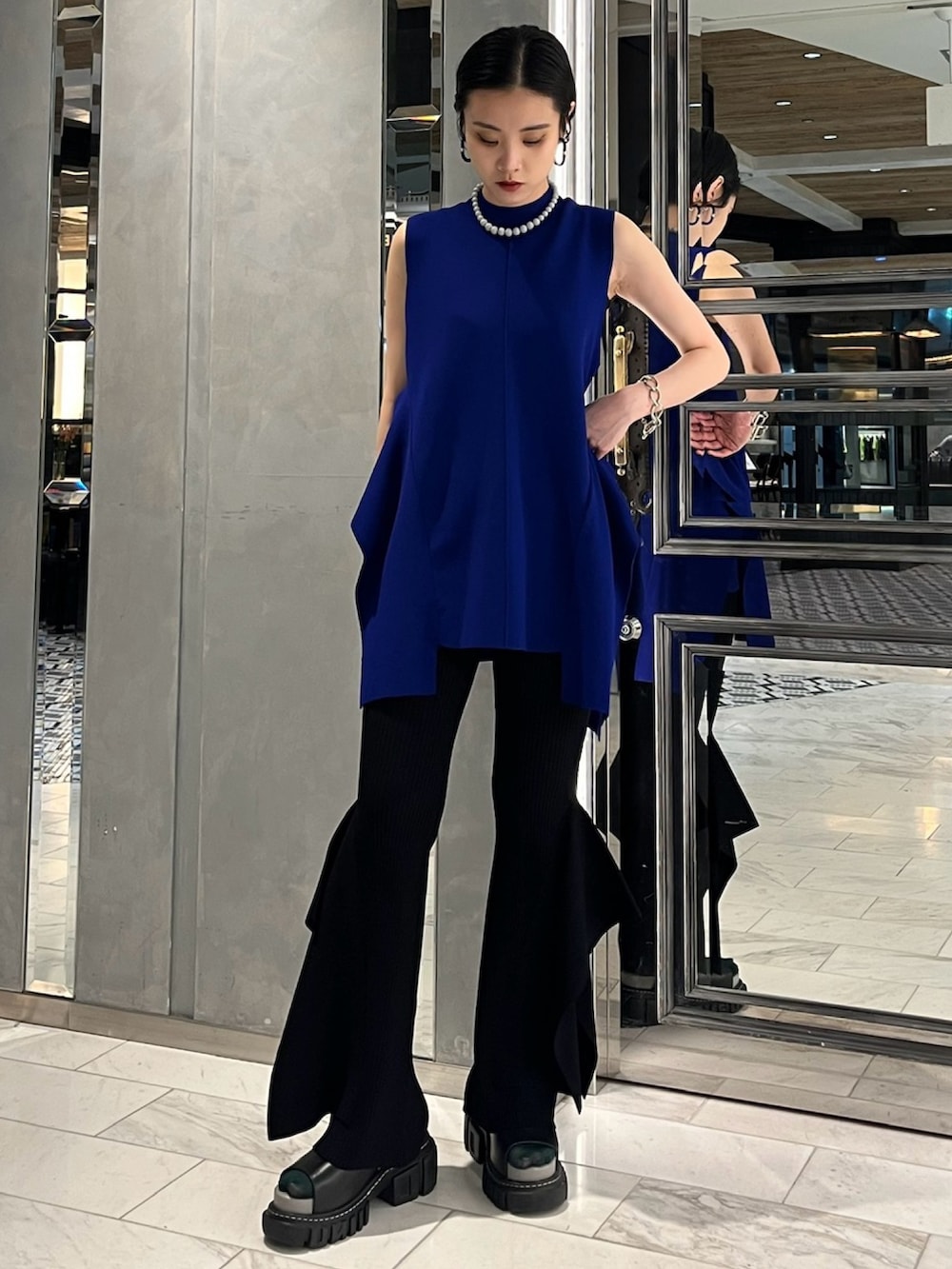 ブルー系のニット/セーター、ブラック系のその他パンツ、その他のサンダルを着用したレディースの春コーディネートの2枚目の写真