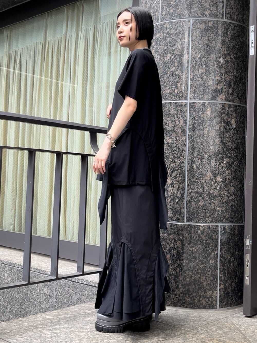 ブラック系のTシャツ/カットソー、ブラック系のスカート、グレー系のローファーを着用したレディースの秋コーディネートの4枚目の写真