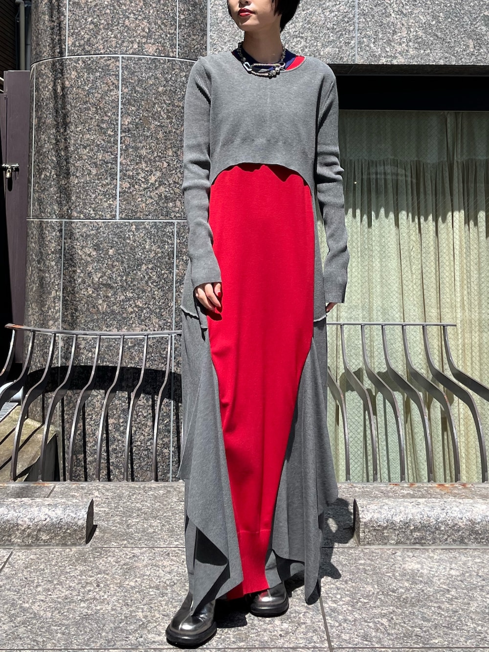 グレー系のワンピース、シルバー系のブーツ、シルバー系のネックレスを着用したレディースの秋コーディネートの2枚目の写真