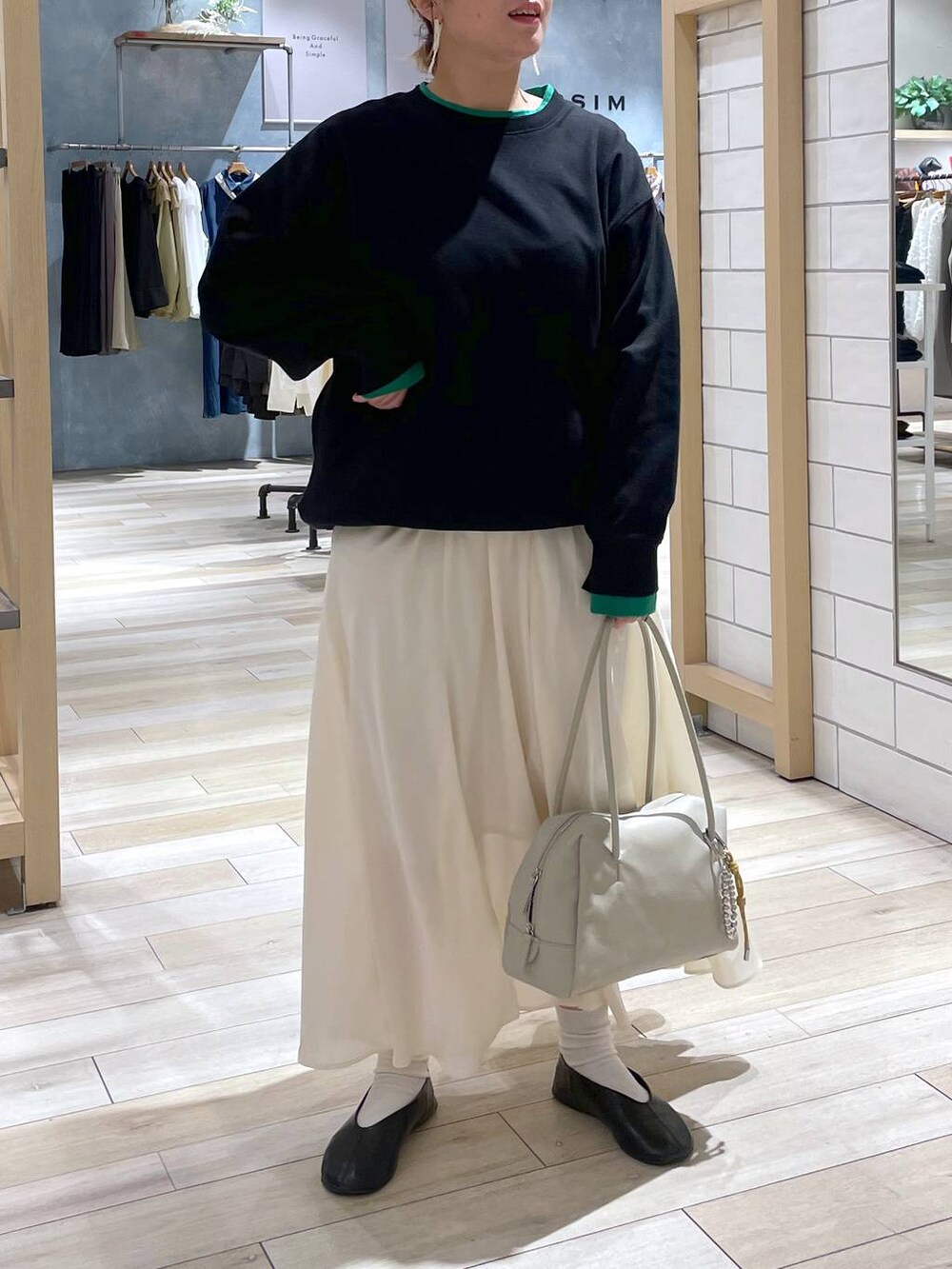 ブラック系のTシャツ/カットソー、ホワイト系のスカートを着用したレディースの冬コーディネートの2枚目の写真