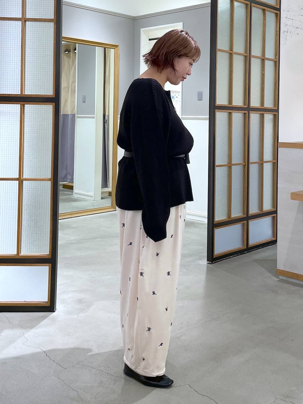 ホワイト系のその他パンツ、ブラック系のカーディガン/ボレロ、ブラック系のベルトを着用したレディースの秋コーディネートの3枚目の写真
