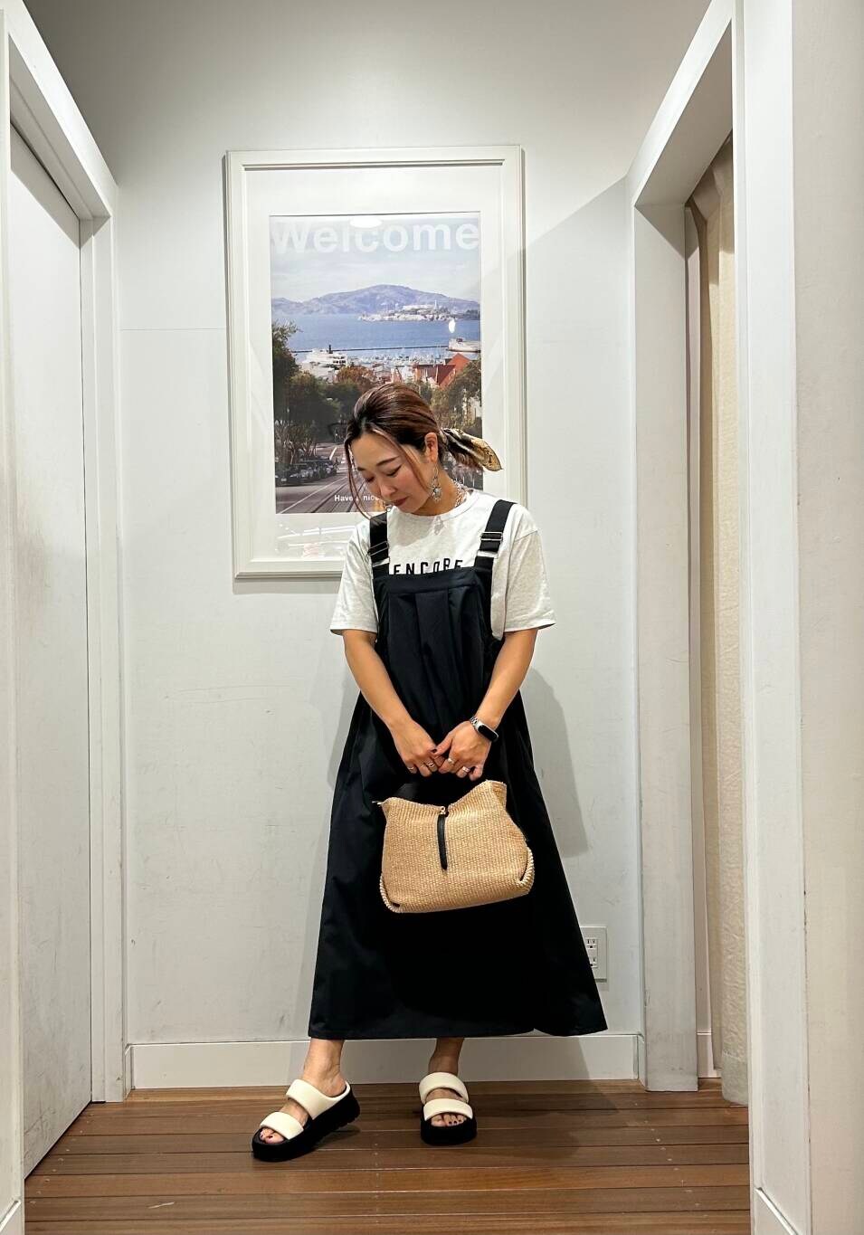 グレー系のワンピース、グレー系のTシャツ/カットソー、ホワイト系のサンダルを着用したレディースの春コーディネートの2枚目の写真