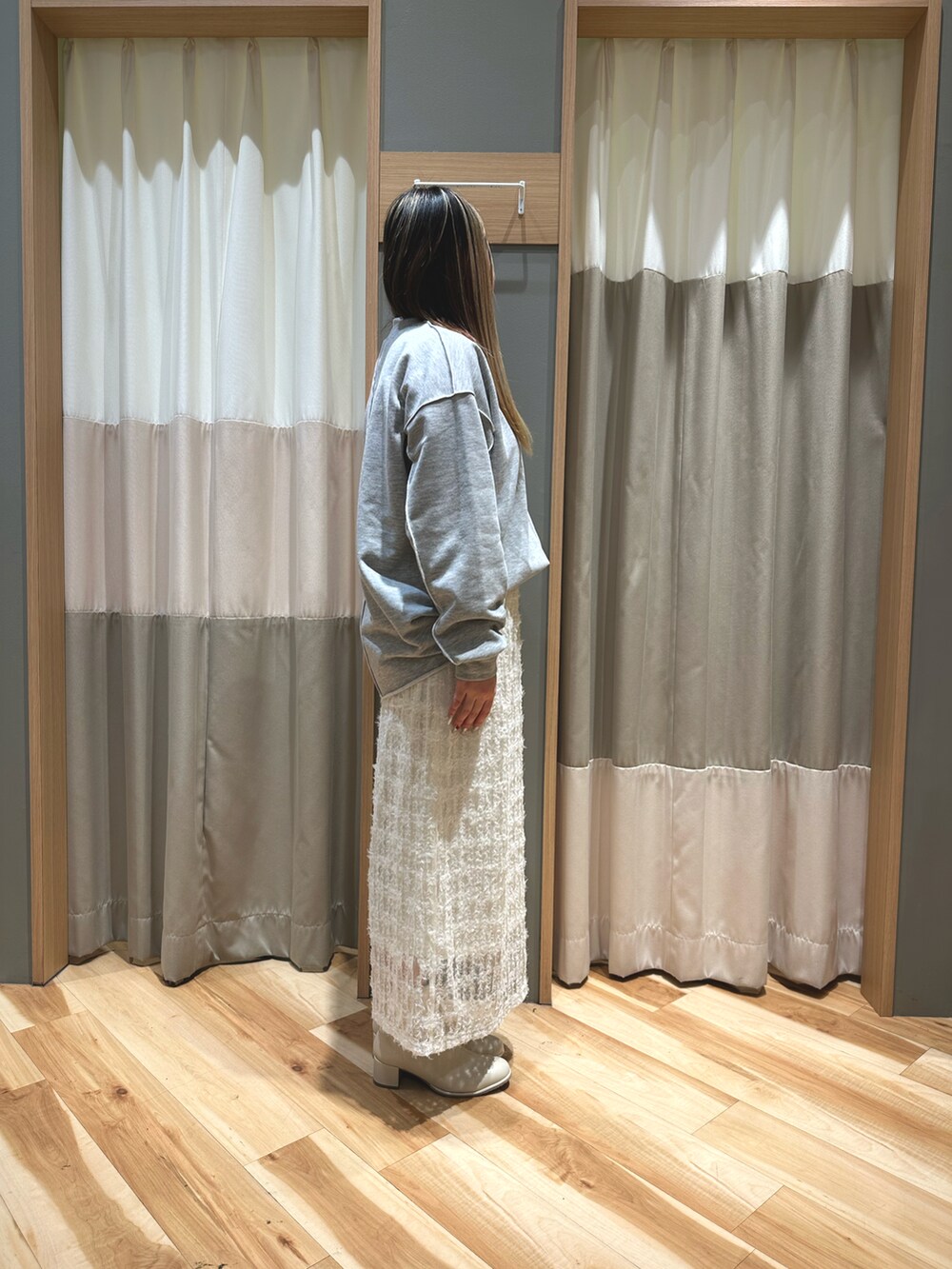 グレー系のトップス、ホワイト系のTシャツ/カットソー、ホワイト系のスカートを着用したレディースの冬コーディネートの4枚目の写真