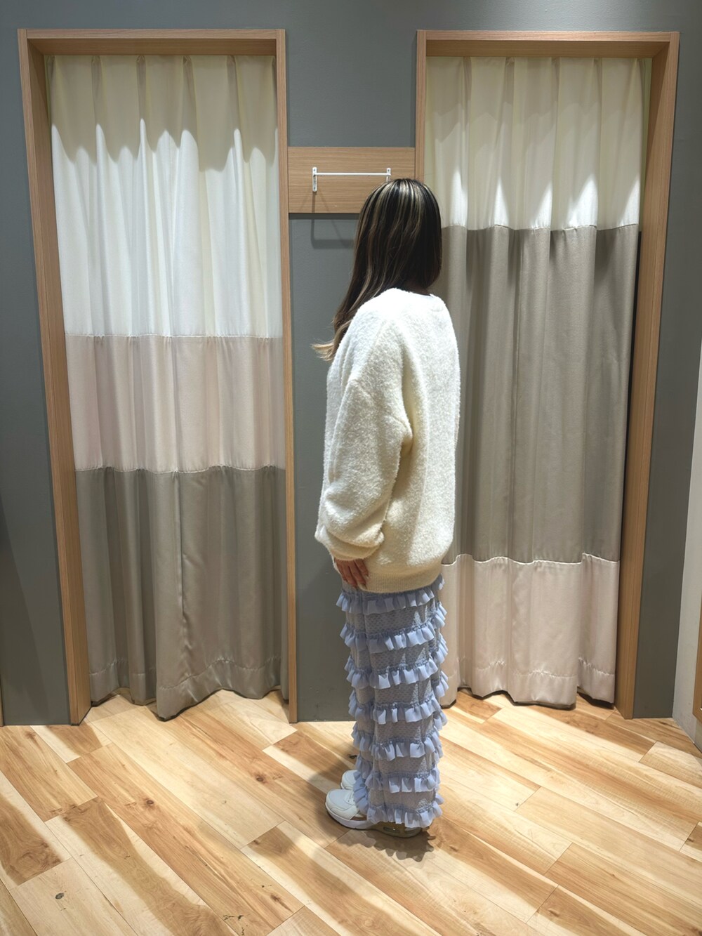 ブラック系のTシャツ/カットソー、ホワイト系のニット/セーター、ブルー系のスカートを着用したレディースの冬コーディネートの2枚目の写真