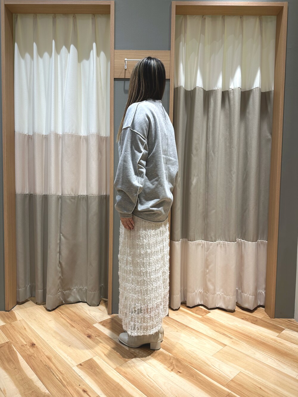 グレー系のトップス、ホワイト系のTシャツ/カットソー、ホワイト系のスカートを着用したレディースの冬コーディネートの2枚目の写真