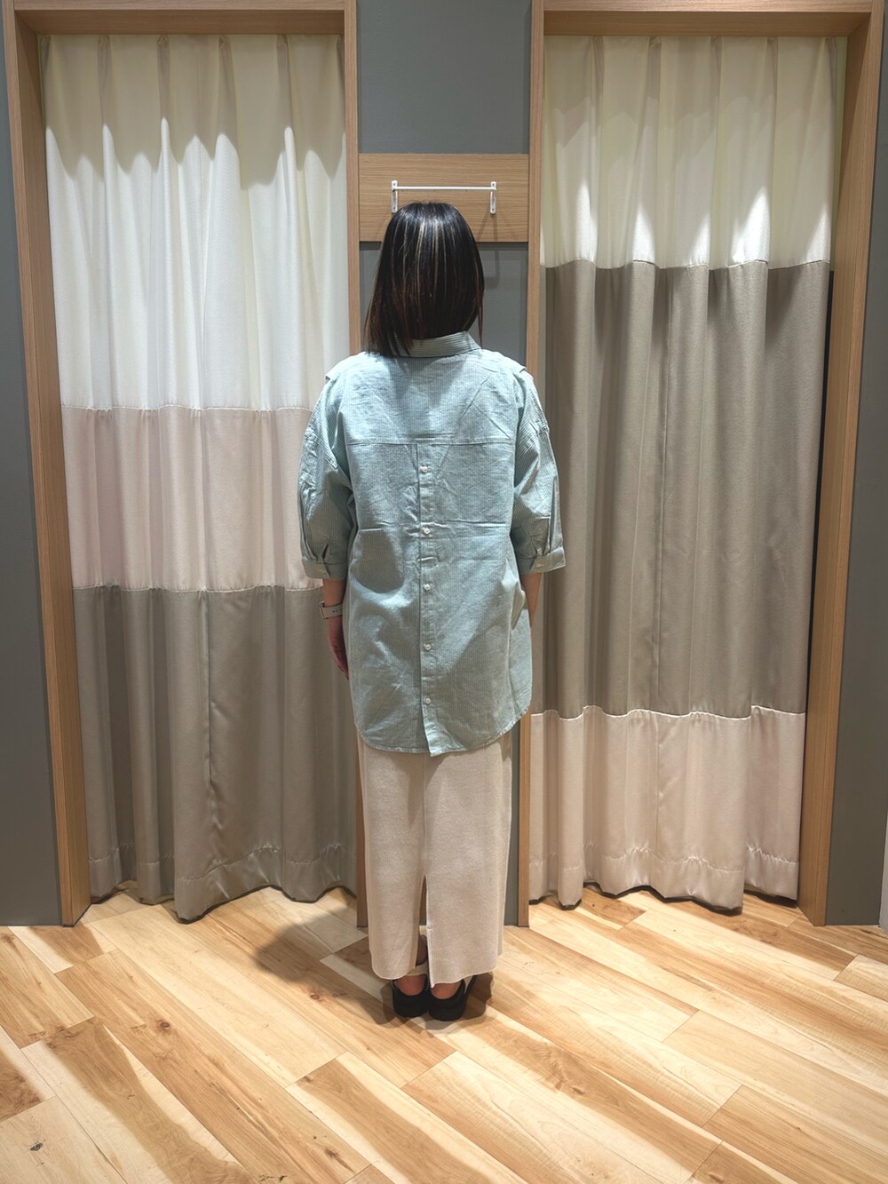 グリーン系のトップス、ベージュ系のスカート、ホワイト系のサンダルを着用したレディースの春コーディネートの3枚目の写真