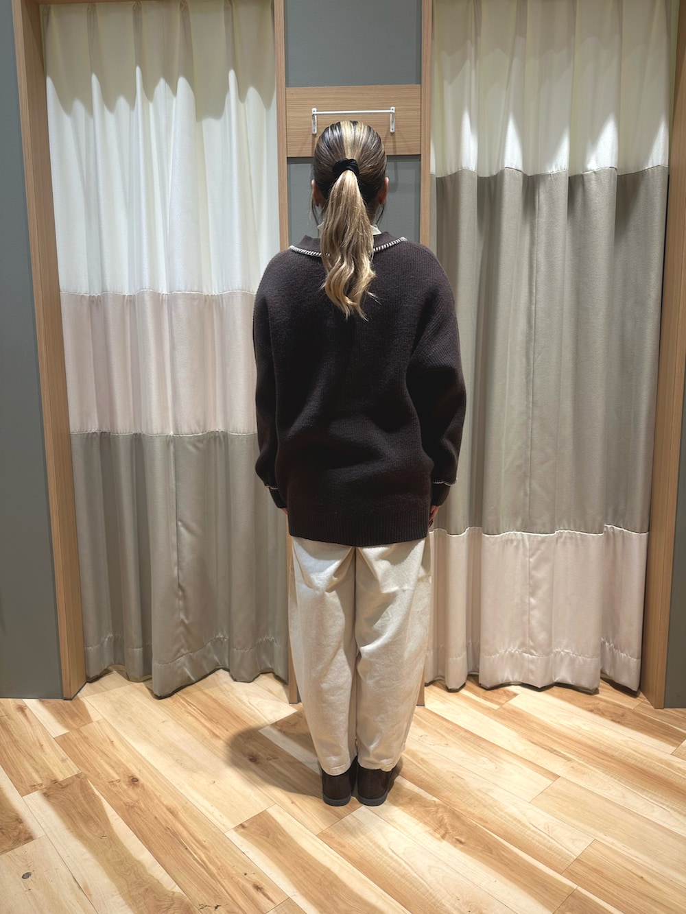 ホワイト系のニット/セーター、ブラウン系のカーディガン/ボレロ、ホワイト系のパンツを着用したレディースの冬コーディネートの3枚目の写真