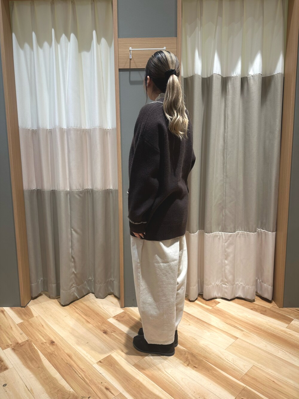 ホワイト系のニット/セーター、ブラウン系のカーディガン/ボレロ、ホワイト系のパンツを着用したレディースの冬コーディネートの2枚目の写真