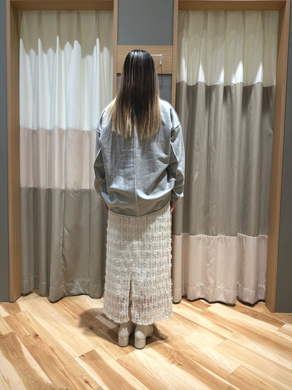 グレー系のトップス、ホワイト系のTシャツ/カットソー、ホワイト系のスカートを着用したレディースの冬コーディネートの3枚目の写真